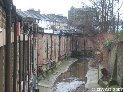 Quaggy flowing along the back of the site. The building is planned to rise five storeys directly from the riverbank, 'canyoning' the river. The Quaggy flowing along the back of the site